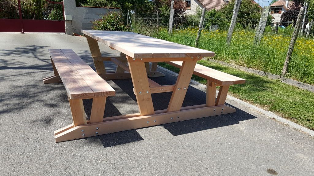 Table de pique-nique et bancs massifs devant une prairie fleurie, fabrication française SNMB — bois autoclave classe 4