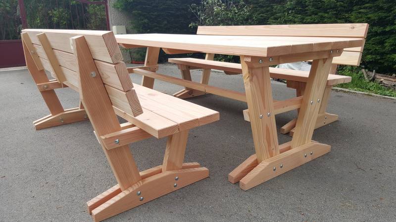 Vue arrière rapprochée du dossier à lames horizontales d'un banc en bois, table assortie en arrière-plan, fabrication française SNMB — bois autoclave classe 4