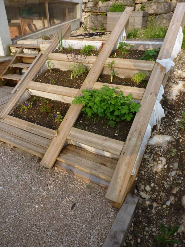 Carrés d'aromatiques plantés dans la jardinière inclinée épousant le talus, fabrication française SNMB Menuiserie Bertin