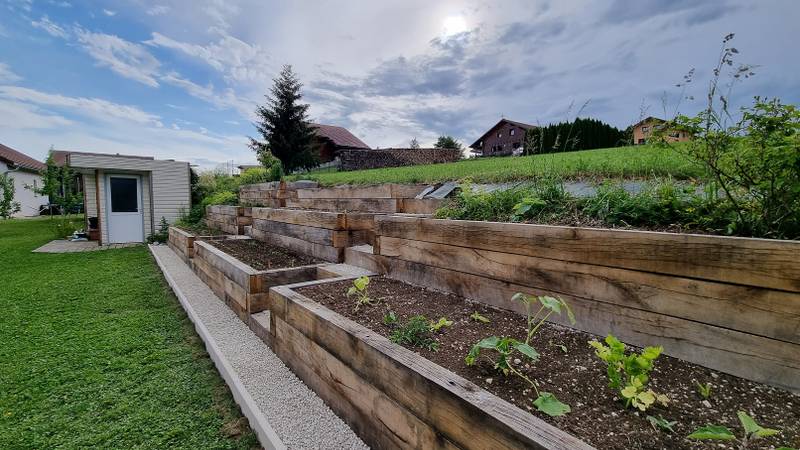 Jardinière étagée sous un ciel nuageux, épicéa et prairie en arrière-plan, fabrication française SNMB Menuiserie Bertin