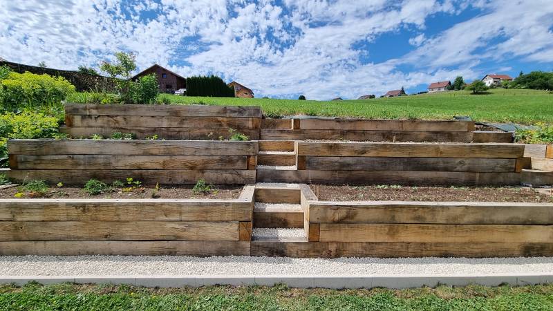 Vue frontale de la jardinière en gradins avec escalier central en gravier blanc, fabrication française SNMB Menuiserie Bertin