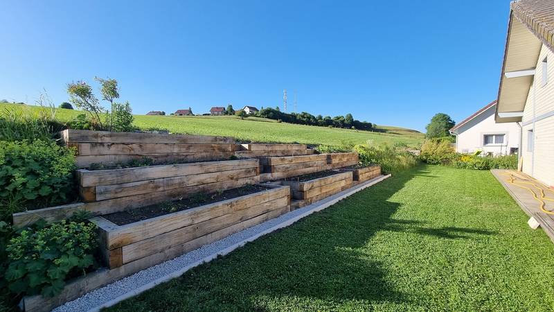 Jardinière en pente en traverses de chêne, vue d'ensemble au soleil du matin, fabrication française SNMB Menuiserie Bertin